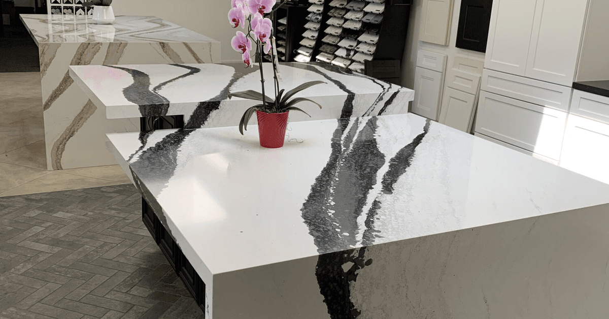 Close view of a white stone island with bold dark veining running across the surface