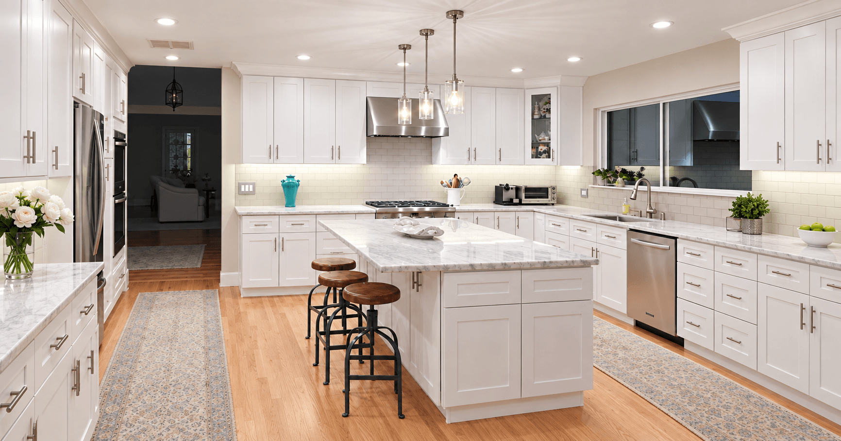Wide white kitchen with a stone-topped island, pendant lights, and wood floors